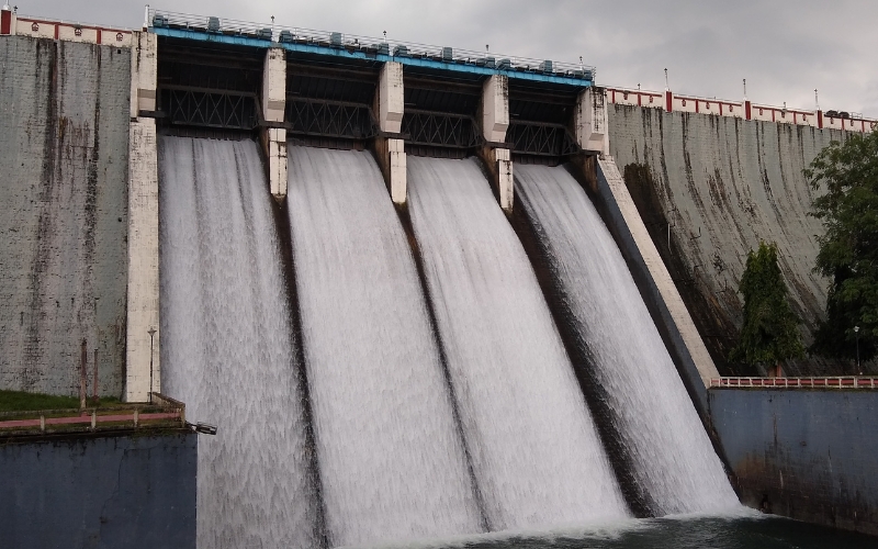 A breathtaking view of Kanjirapuzha Dam, surrounded by lush green hills and a serene reservoir reflecting the natural beauty of Kerala.