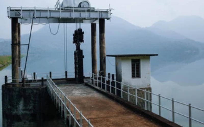 A scenic view of Pothundi Dam, with its calm reservoir and surrounding lush hills, reflecting the natural beauty of Kerala.